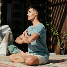 Hombre meditando al aire libre en posición de relajación y concentración