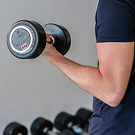 Persona levantando una mancuerna en el gimnasio durante una rutina de entrenamiento