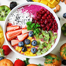 Bowl de frutas coloridas con fresas, arándanos, kiwi, mango y granada sobre base de smoothie